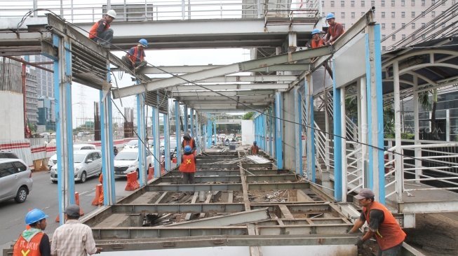 Sejumlah pekerja membongkar halte TransJakarta BNN di kawasan Cawang, Jakarta, Rabu (23/5).