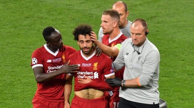 Pemain depan Liverpool Mohamed Salah (tengah) meninggalkan lapangan karena mendapatkan cedera. Sergei SUPINSKY / AFP