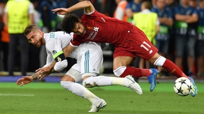 Pemain Liverpool Mohamed Salah (kanan) dengan bek Real Madrid Sergio Ramos jatuh saat berebut bola di final Liga Champions. GENYA SAVILOV / AFP 