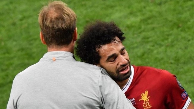 Pemain Liverpool Mohamed Salah (kanan) coba ditenangkan oleh manajer Liverpool Jurgen Klopp saat meninggalkan lapangan karena cedera. Sergei SUPINSKY / AFP