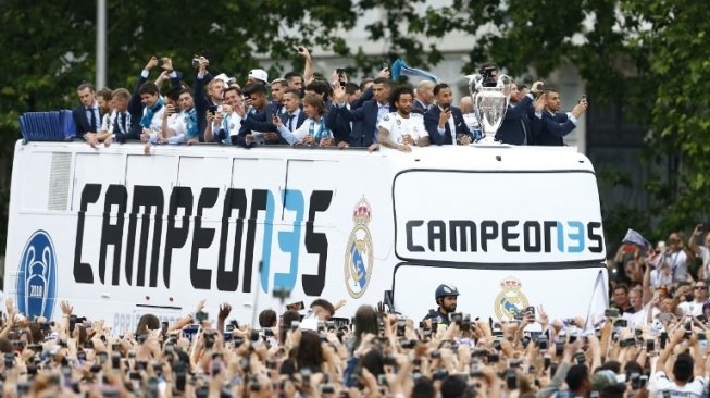 Para pemain Real Madrid merayakan juara Liga Champions melakukan parade dengan bus atas terbuka di Cibeles square, Madrid pada Minggu (27/5/2018). BENJAMIN CREMEL / AFP
