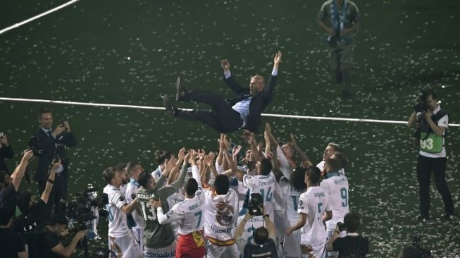 Para pemain Real Madrid mengangkat sang pelatih Zinedine Zidane. GABRIEL BOUYS / AFP 