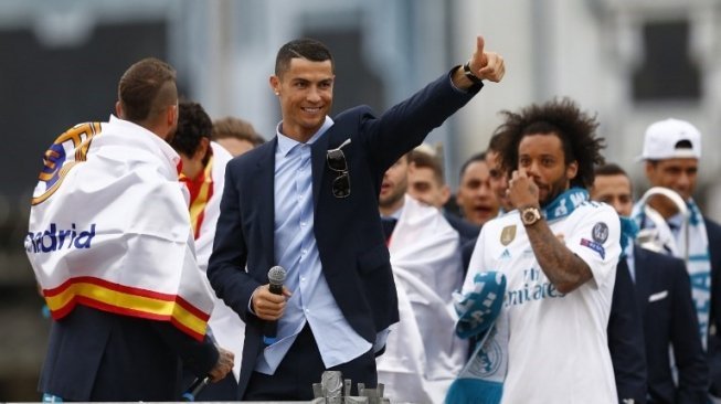 Bintang Real Madrid Cristiano Ronaldo bersama rekan setimnya melakukan parade dengan bus atas terbuka merayakan sukses mereka menjuarai Liga Champions. BENJAMIN CREMEL / AFP 