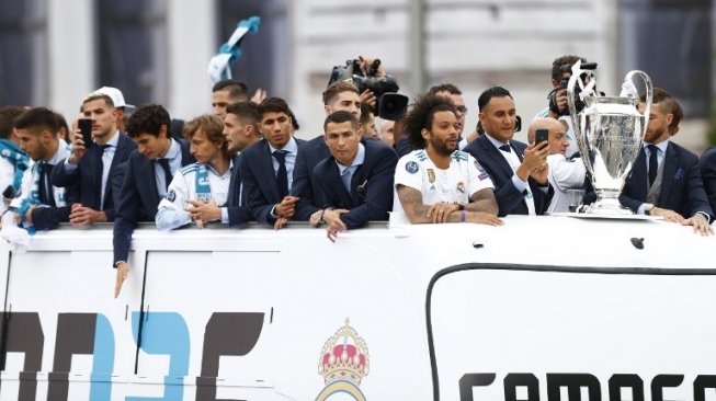 Para pemain Real Madrid melakukan parade juara Liga Champions dengan bus atas terbuka di jalan-jalan ibukota Spanyol. BENJAMIN CREMEL / AFP
