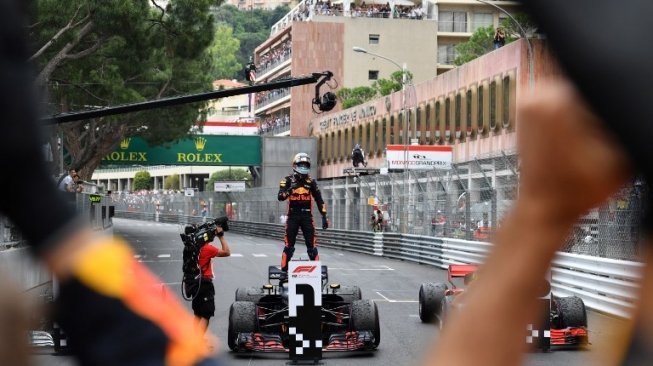 Pebalap Red Bull Racing Daniel Ricciardo berdiri di atas mobilnyav merayakan kemenangannya di GP F1 Monaco. Andrej ISAKOVIC / AFP