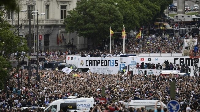 Ribuan fans menyambut para pemain Real Madrid yang membawa trofi Liga Champions di bus atas terbuka di alun-alun Cibeles, Madrid. OSCAR DEL POZO / AFP