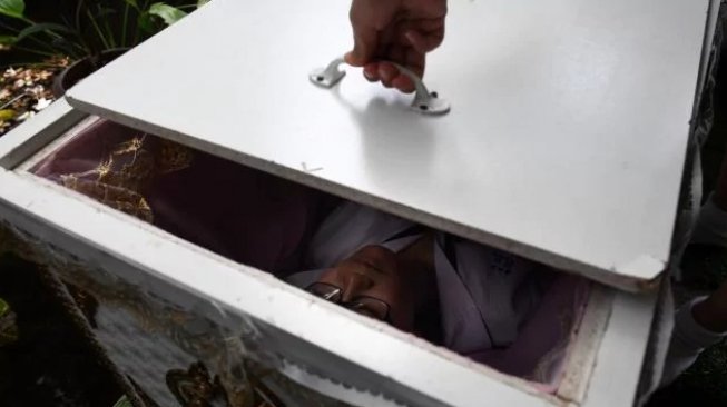 Pengunjung The Kid-Mai Death Cafe yang berani masuk ke peti mati mendapat diskon. (AFP/Lillian Suwanrumpha)