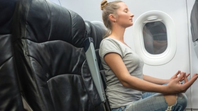 Ilustrasi yoga dalam pesawat terbang. (Shutterstock)