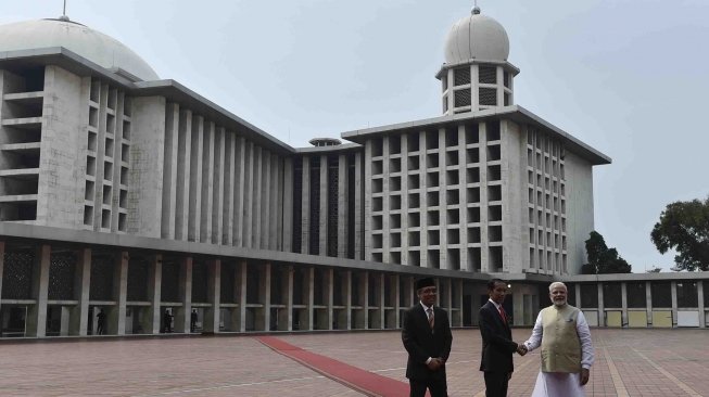 Presiden Joko Widodo (tengah) mendampingi PM India Narendra Modi (kanan) mendengarkan penjelasan dari Wakil Ketua Badan Pelaksana Pengelola Masjid Istiqlal Bahrul Hayat ketika mengunjungi Masjid Istiqlal, Jakarta, Rabu (30/5). 