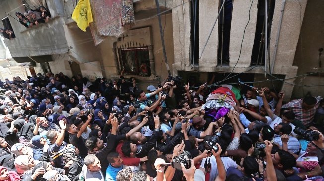 Sejumlah besar warga Palestina yang berduka menghadiri pemakaman jenazah Razan Al Najjar, Sabtu (2/6/2018) di Khan Younis, usai dipastikan meninggal setelah ditembak tentara Israel dekat pagar pembatas Gaza. [Mahmud Hams/AFP]