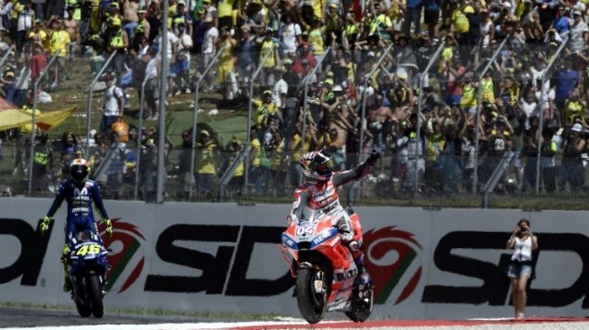 Pebalap Ducati Andrea Dovizioso diikuti Valentino Rossi usai menyentuh garis finis di MotoGP Italia yang berlangsung di Sirkuit Mugello, Minggu (3/6/2018) [AFP]