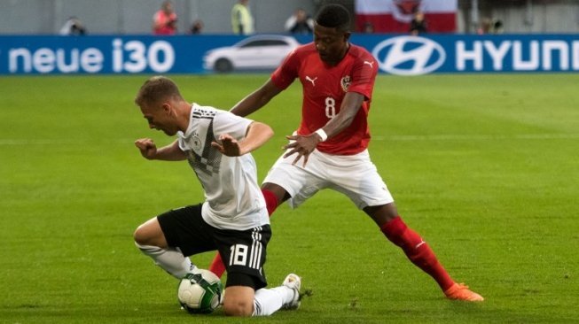 Pemain Jerman Joshua Kimmich berebut bola dengan pemain Austria David Alaba [AFP]