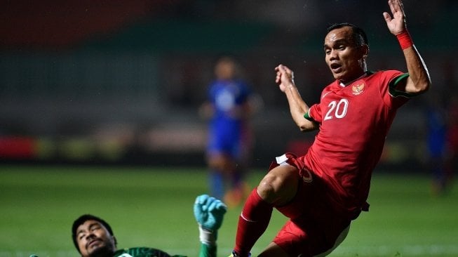 Pemain Timnas Indonesia U-23 Riko Simanjuntak (kanan) berjibaku dengan penjaga gawang Timnas Thailand U-23 Nont Muangngam dalam pertandingan uji coba di Stadion Pakansari, Cibinong, Bogor, Jawa Barat, Minggu (3/6) malam. ANTARA 