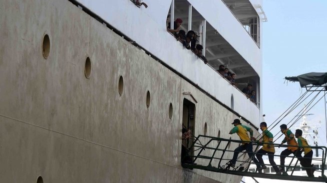 Sejumlah buruh angkut berlarian menuju kapal Pelni Nggapulu asal Makassar, Sulawesi Selatan, ketika berlabuh di Terminal Gapura Surya Nusantara, Pelabuhan Tanjung Perak, Surabaya, Jawa Timur, Senin (4/6). 