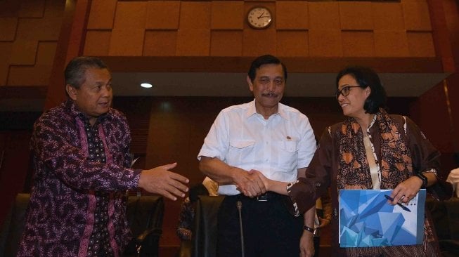 Menko Bidang Kemaritiman Luhut Binsar Pandjaitan (tengah) selaku Ketua Panitia Nasional penyelenggaraan pertemuan IMF-World Bank 2018 berbincang dengan Menteri Keuangan Sri Mulyani (kanan) dan Gubernur BI Perry Warjiyo seusai memberikan keterangan pers di Kementerian Keuangan, Jakarta, Senin (4/6).