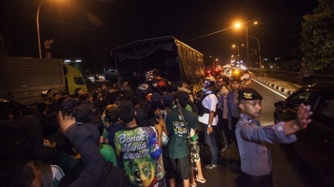 Sejumlah suporter Persebaya, Bonek menaiki truk Polisi saat pemulangan Bonek di kawasan Giwangan, Yogyakarta, Minggu (3/6). Polda DI Yogyakarta menerjunkan sejumlah truk dan ratusan personil guna memfasilitasi pemulangan Bonek menyusul dibatalkannya pertandingan sepak bola antara Persija melawan Persebaya yang dijadwalkan bertanding di Stadion Sultan Agung, Bantul pada Minggu (3/6) malam, akibat terjadinya kerusuhan antar oknum suporter Persebaya dan Persija sebelum pertandingan. ANTARA