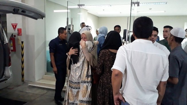 Olla Ramlan memeluk sambil menangis salah seorang kerabat. Olla sangat terpukul dengan meninggalnya sang ayah, Muhammad Ramlan. (Ismail/Suara.com)