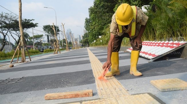 Pekerja menyelesaikan proyek perbaikan pedestrian di kawasan Gelora Bung Karno (GBK), Senayan, Jakarta, Selasa (5/6). 