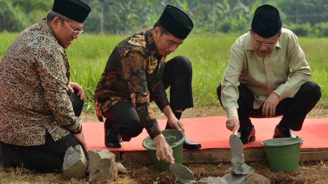 Presiden Joko Widodo (tengah) bersama Wakil Presiden Jusuf Kalla (kanan) melakukan peletakan batu pertama pembangunan Universitas Islam Internasional Indonesia (UIII) yang masuk ke dalam proyek strategis nasional disaksikan Gubernur Jawa Barat Ahmad Heryawan di Depok, Jawa Barat, Selasa (5/6). 