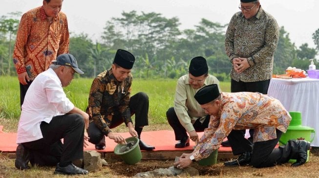 Presiden Joko Widodo (ketiga kiri) bersama Wakil Presiden Jusuf Kalla (ketiga kanan) melakukan peletakan batu pertama pembangunan Universitas Islam Internasional Indonesia (UIII) yang masuk ke dalam proyek strategis nasional dengan dibantu Menteri Agama Lukman Hakim Saifuddin (kedua kanan) dan disaksikan Menristek Dikti M Nasir (kiri), Menteri PUPR Basuki Hadimuljono (kedua kiri) dan Gubernur Jawa Barat Ahmad Heryawan di Depok, Jawa Barat, Selasa (5/6). 