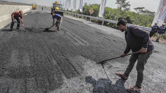 Petugas mengaspal jalan yang akan digunakan untuk jalur tol fungsional di kawasan Pemalang-Batang, Jawa Tengah, Kamis (7/6).