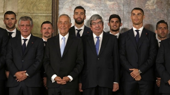 Bintang Portugal Cristiano Ronaldo (kedua kanan) bersama rekan setimnya berfoto dengan Presiden Portugal Marcelo Rebelo de Sousa (kedua kiri) dan pelatih Portugal Fernando Santos di Belem National Coach Museum, Lisbon. JOSE MANUEL RIBEIRO / AFP
