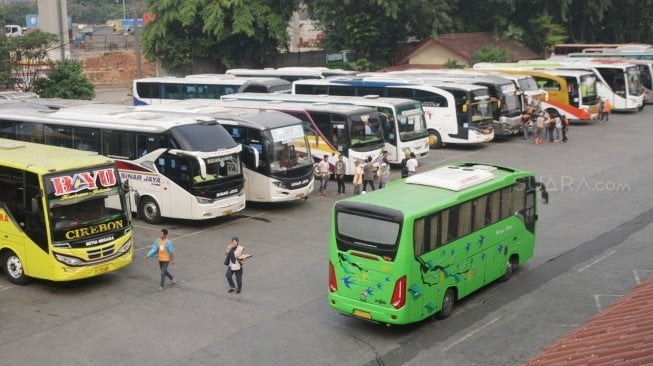 Sejumlah pemudik terlihat bergegas sementara sebagian lainnya menunggu bus di Terminal Kampung Rambutan, Jakarta, Sabtu (9/6/2018). [Suara.com/Oke Atmaja]