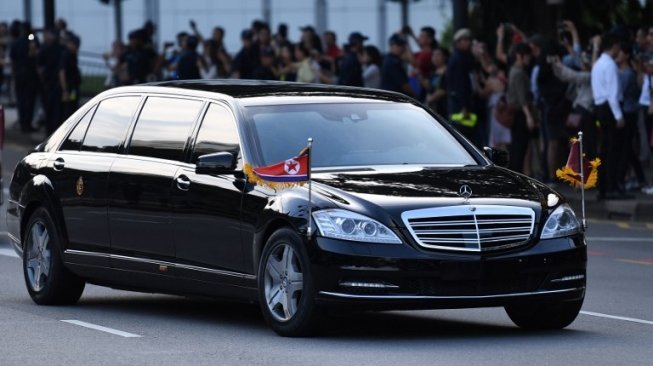 Mobil yang membawa Pemimpin Korea Utara, Kim Jong Un tiba The Istana, Singapura, Minggu (10/6/2018). [AFP/Anthony Wallace]