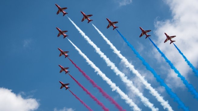 Tim aerobatic kebanggaan Britania Raya, The Red Arrows, tengah mempertunjukkan formasi arrows dalam Trooping The Colour melintas Istana Buckingham [Shutterstock].