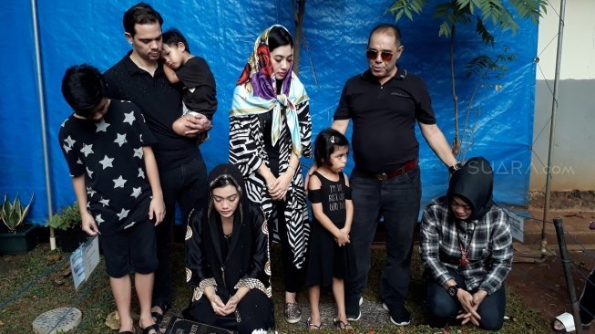 Keluarga berziarah ke makam Jupe di TPU Pondok Ranggon, Cipayung, Jakarta Timur, Minggu (10/6/2018). [Suara.com/Ismail]
