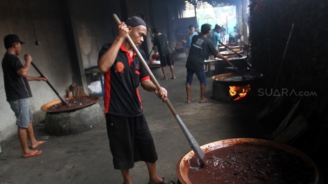 Pekerja membuat dodol Betawi di Kalibata, Jakarta, Selasa (12/6). 