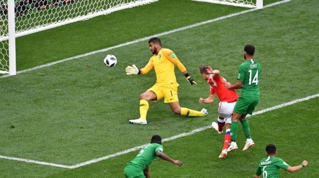 Pemain Rusia Denis Cheryshev menjebol gawang Arab Saudi yang dikawal Abdullah di laga perdana Grup A Piala Dunia 2018, Kamis (14/6/2018) [AFP]