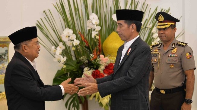 Presiden Joko Widodo (kedua kanan) berjabat tangan dengan Wakil Presiden Jusuf Kalla (kiri) di acara Silahturahmi Idul Fitri 1 Syawal 1439 H di Istana Kepresidenan Bogor, Jawa Barat, Jumat (15/6).