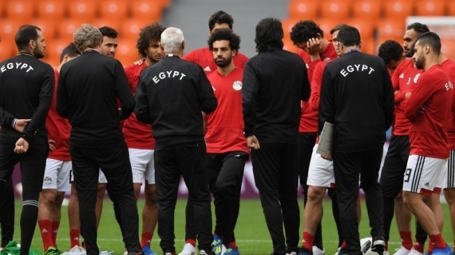 Mohamed Salah (tengah) mendengar instruksi pelatih Hector Raul Cuper sebelum melakukan sesi latihan di Ekaterinburg Stadium. JORGE GUERRERO / AFP 