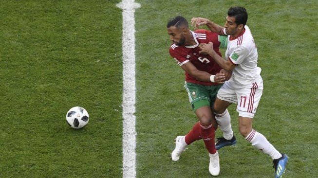 Pemain Maroko Mehdi Benatia berebut bola dengan pemain Iran dalam pertandingan Grup B Piala Dunia 2018 [AFP]