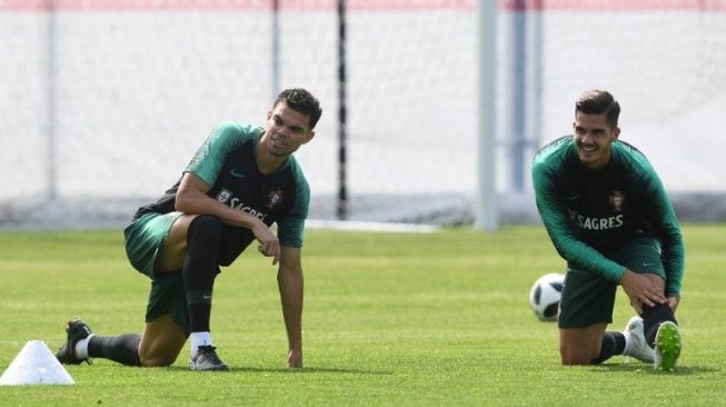 Dua pemain Portugal Pepe (kiri) dan Andre Silva melakukan pemanasan dalam sesi latihan [AFP]