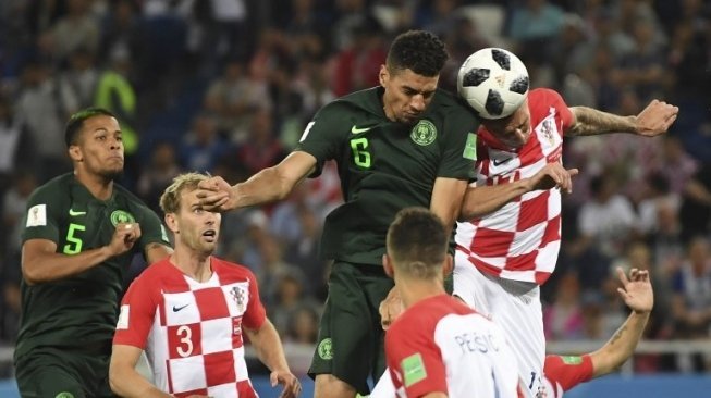 Pemain depan Kroasia Mario Mandzukic (kanan) berebut bola dengan bek Nigeria Leon Balogun. OZAN KOSE / AFP