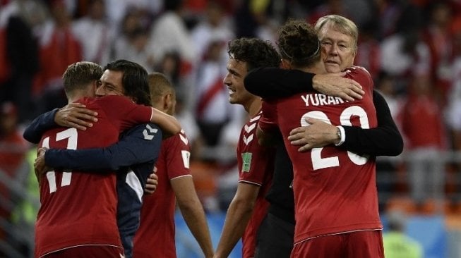 Pelatih Denmark Age Hareide memeluk dan memberikan ucapan selamat kepada Yussuf Poulsen (kanan). Filippo MONTEFORTE / AFP