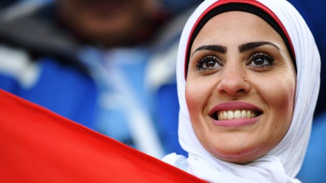 Seorang perempuan suporter timnas Mesir tampak memberi dukungan dalam laga Grup A Piala Dunia 2018 antara Mesir vs Uruguay di Ekaterinburg Arena, Rusia, Jumat (15/6/2018). [JORGE GUERRERO / AFP]