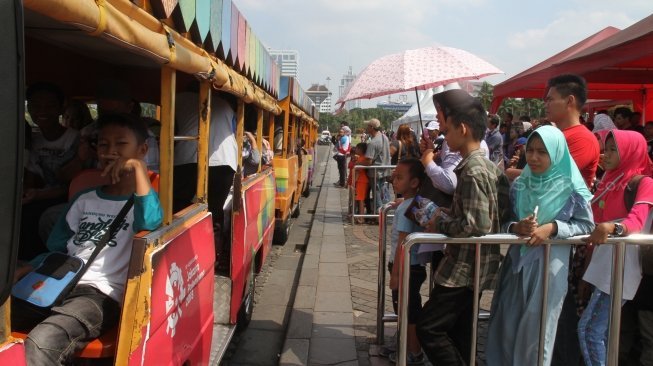 Sejumlah besar warga tampak memanfaatkan periode libur Idul Fitri 1439 H di area Monumen Nasional (Monas), Jakarta, Senin (18/6/2018). [Suara.com/Oke Atmaja]