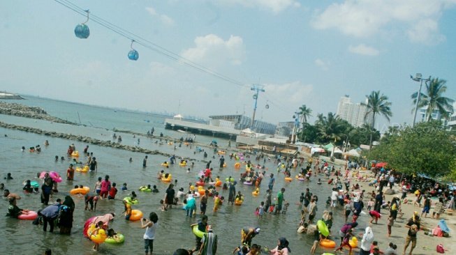 Pengunjung memadati Pantai Karnaval Ancol, Jakarta, Selasa (19/6). 