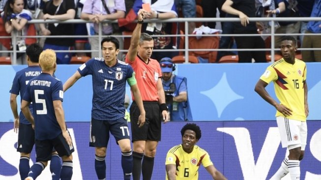 Gelandang Timnas Kolombia, Carlos Sanchez (bawah) diganjar katrtu merah oleh wasit di laga kontra Jepang (Filippo MONTEFORTE / AFP)