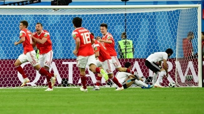 Para pemain Timnas Rusia bergembira usai fullback sekaligus kapten Mesir, Ahmed Fathi mencetak gol bunuh diri (Giuseppe CACACE / AFP)