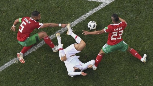 Pemain Portugal Cristiano Ronaldo dijatuhkan pemain Maroko di depan kotak penalti [AFP]