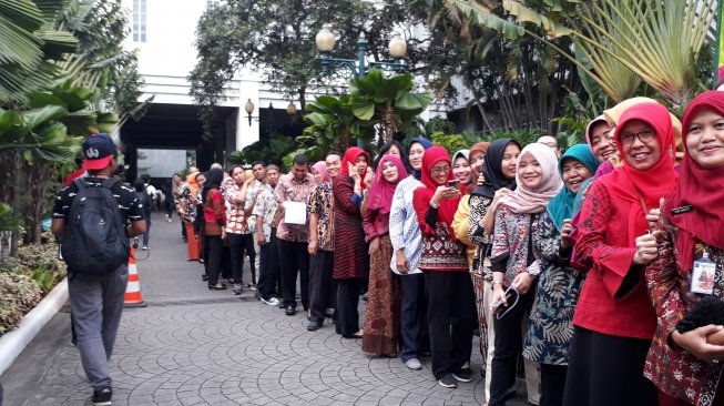 Selfie dan we-fie menunggu antrean untuk jabat tangan dengan Gubernur dan Walikota DKI Jakarta [Suara.com/Ummi Hadyah Saleh].