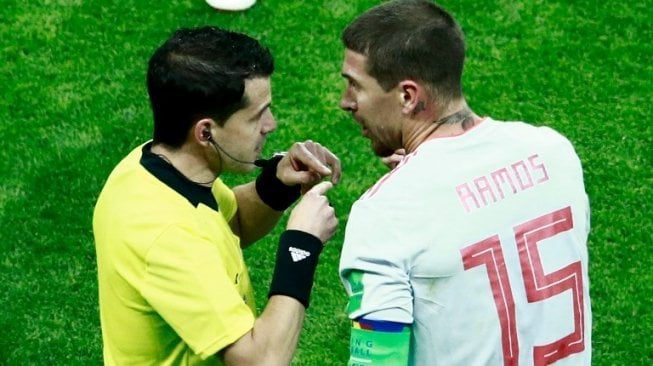 Bek sekaligus kapten Timnas Spanyol, Sergio Ramos, memprotes keputusan wasit di laga kontra Iran (BENJAMIN CREMEL / AFP)