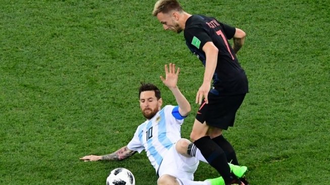 Megabintang Timnas Argentina, Lionel Messi (bawah) berebut bola dengan gelandang Kroasia, Ivan Rakitic yang merupakan rekan setimnya di Barcelona (Martin BERNETTI / AFP)