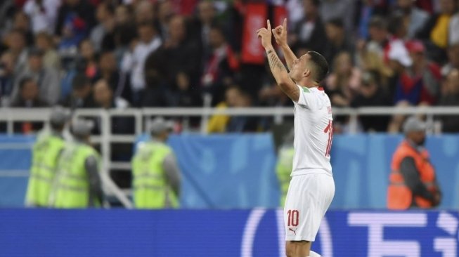 Gelandang Timnas Swiss, Granit Xhaka merayakan golnya ke gawang Serbia (OZAN KOSE / AFP)