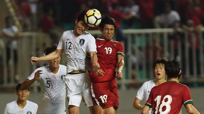 Pemain Timnas Indonesia U-23 Hanif Abdurrauf (kanan) berduel udara dengan pesepakbola Timnas Korsel U-23 Lee Sangmin (kiri) dalam pertandingan uji coba di Stadion Pakansari, Bogor, Sabtu (23/6). [Antara/Akbar Nugroho Gumay]