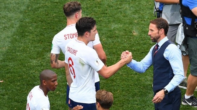 Manajer Timnas Inggris Gareth Southgate (kiri) menyalami bek Harry Maguire usai menghadapi Panama. Johannes EISELE / AFP
